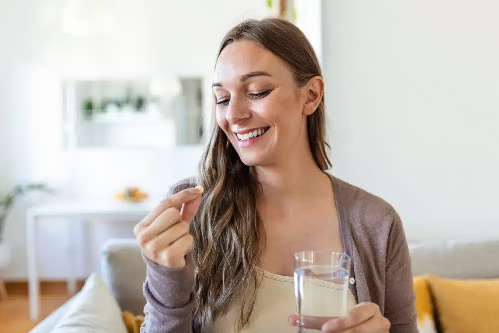 head,shot,portrait,happy,woman,holds,pill,glass,of,water,